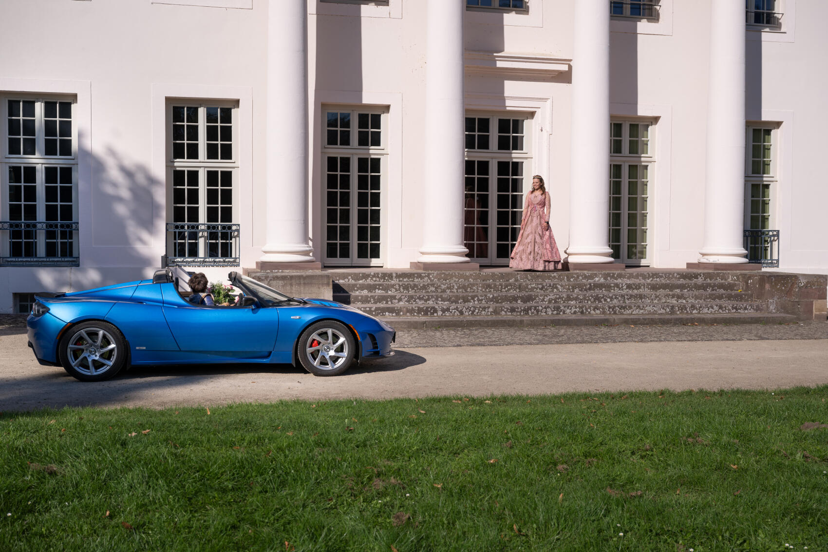 Der Prinz fährt im Tesla Roadster vor das Schloss von Dornröschen